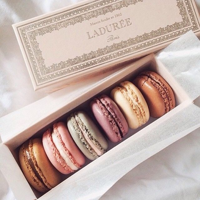 a box filled with macaroons sitting on top of a bed