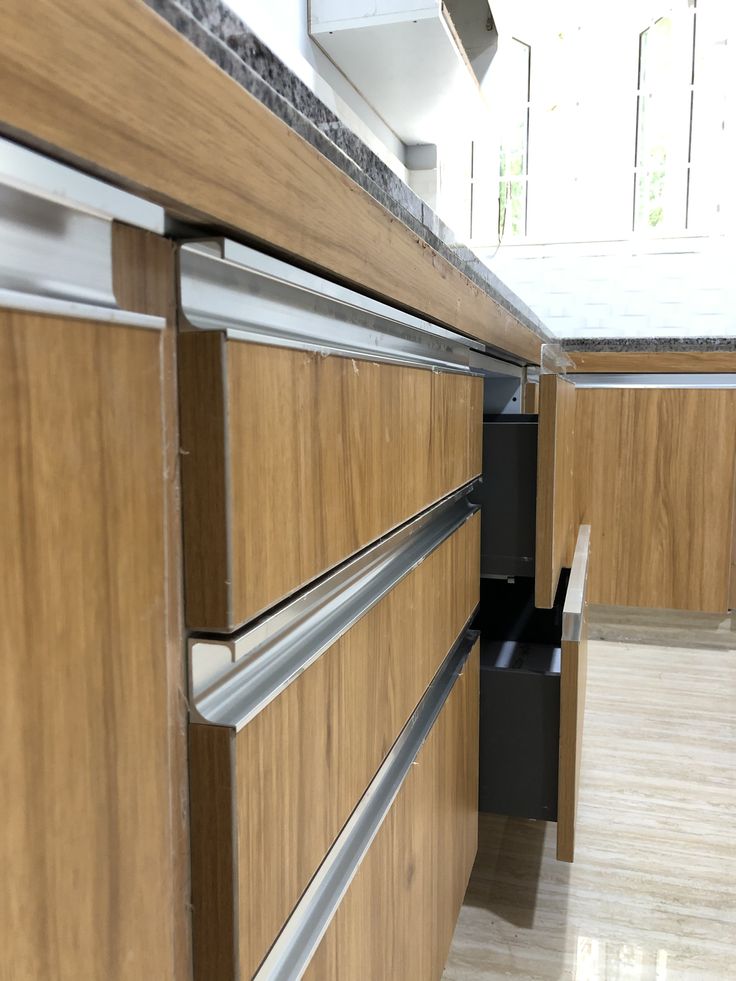 a kitchen with wooden cabinets and stainless steel drawers