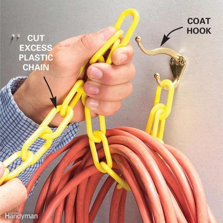 a man is working on an extension cord with the help of a hook and chain