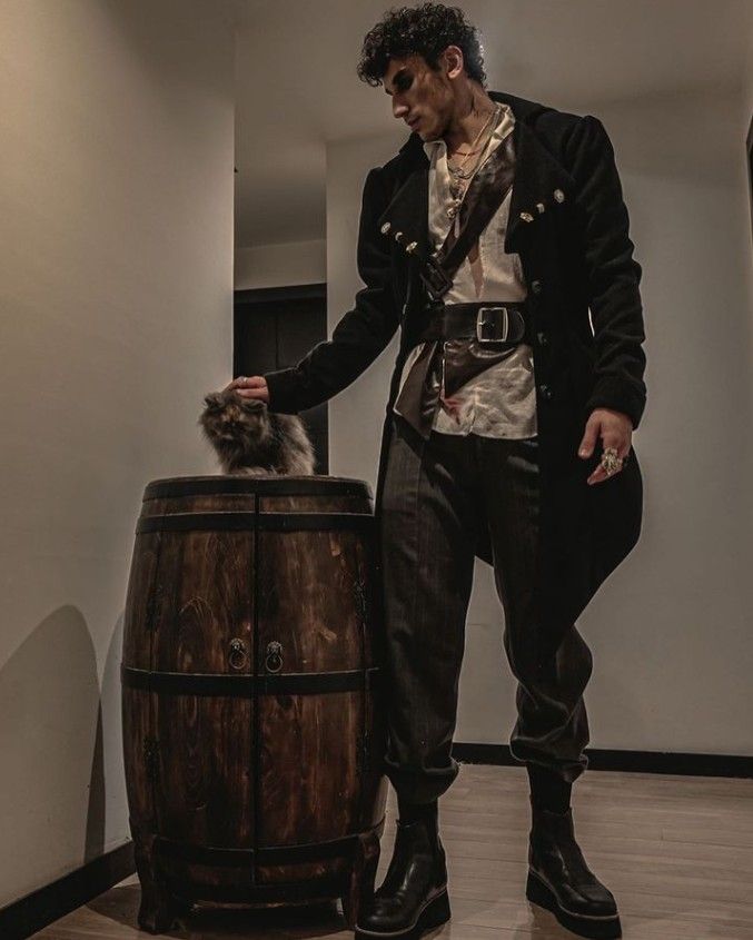 a man standing next to a barrel with a cat on it