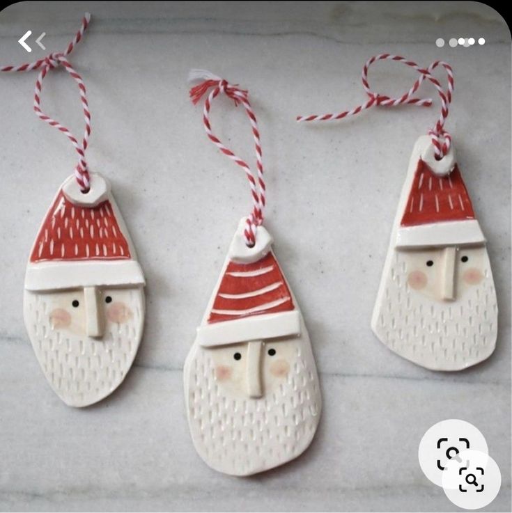 three ceramic ornaments with santa hats on them