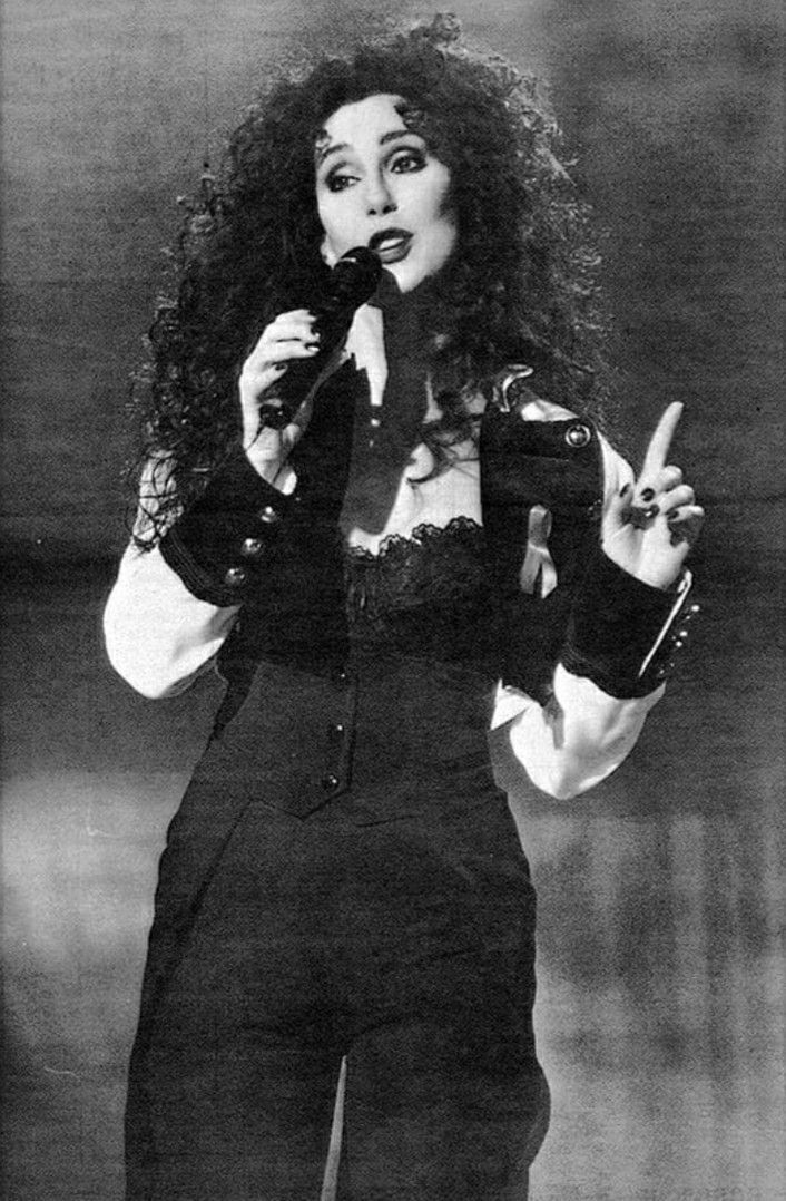 a woman in black and white holding a microphone