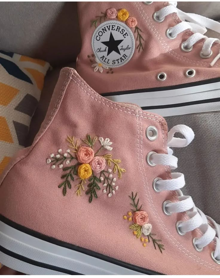 two pink converse sneakers with flowers on them