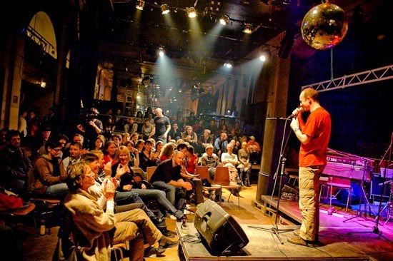 a man standing on top of a stage in front of a crowd