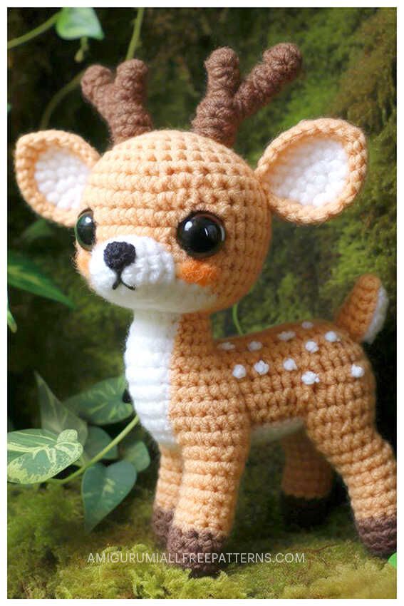 a small crocheted deer is standing in the grass with its eyes wide open