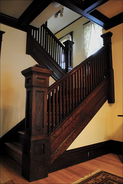 a wooden stair case next to a mirror