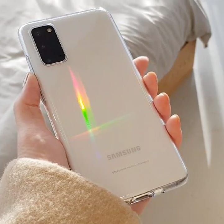 someone is holding their samsung phone in their hand with the light shining on it's back