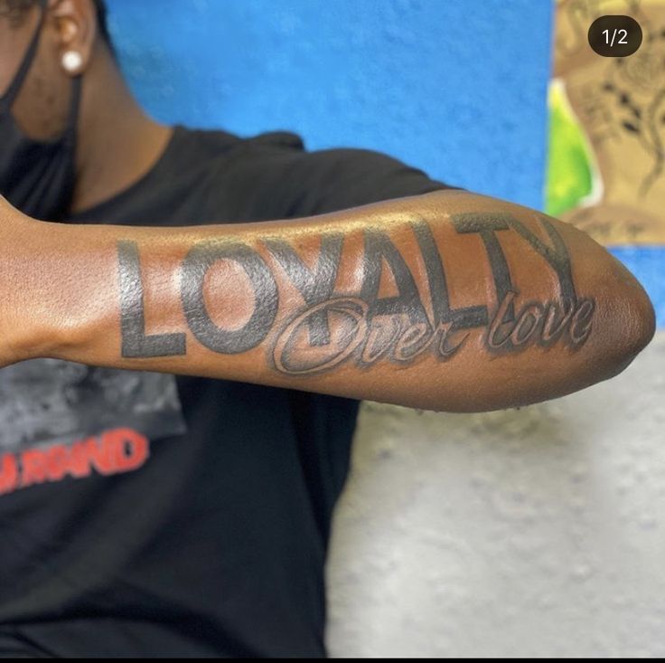 a man with a tattoo on his arm that says lovay over love in cursive writing