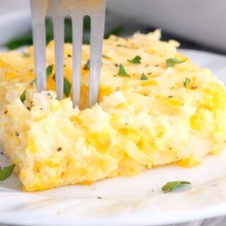 a fork is stuck into an omelet on a plate