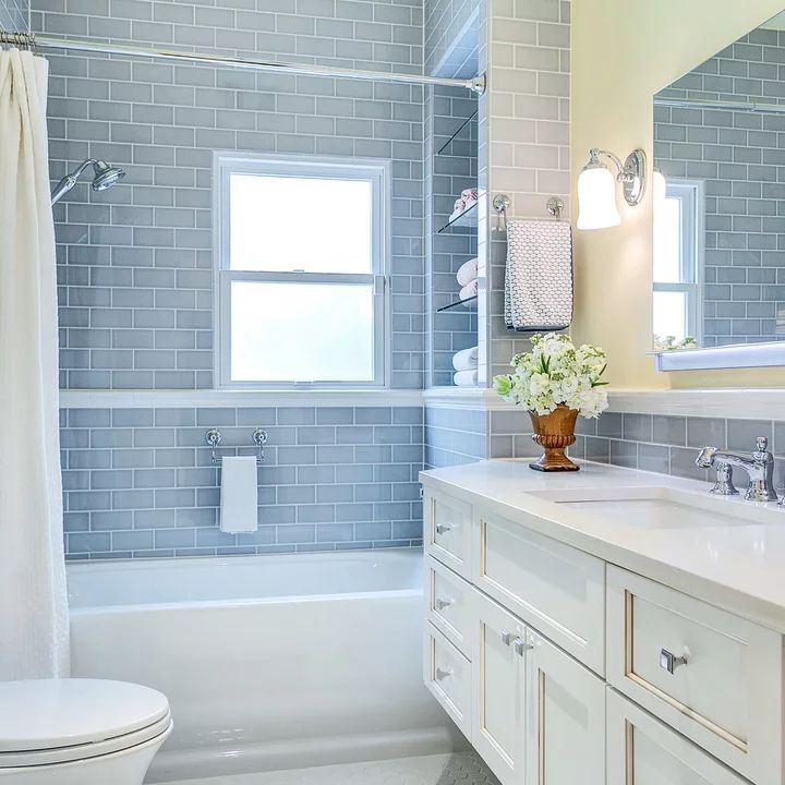 a white bathroom with blue tile on the walls