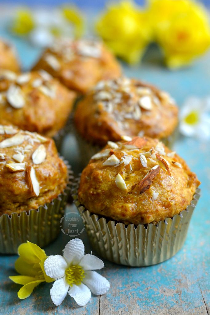 several muffins sitting on top of a blue table next to a white flower