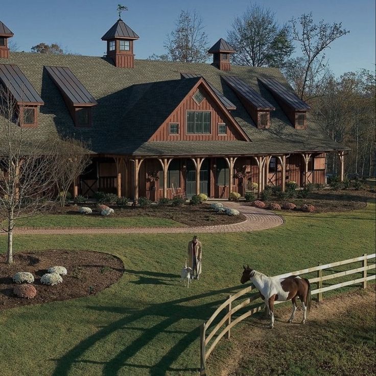 two horses grazing in front of a large house