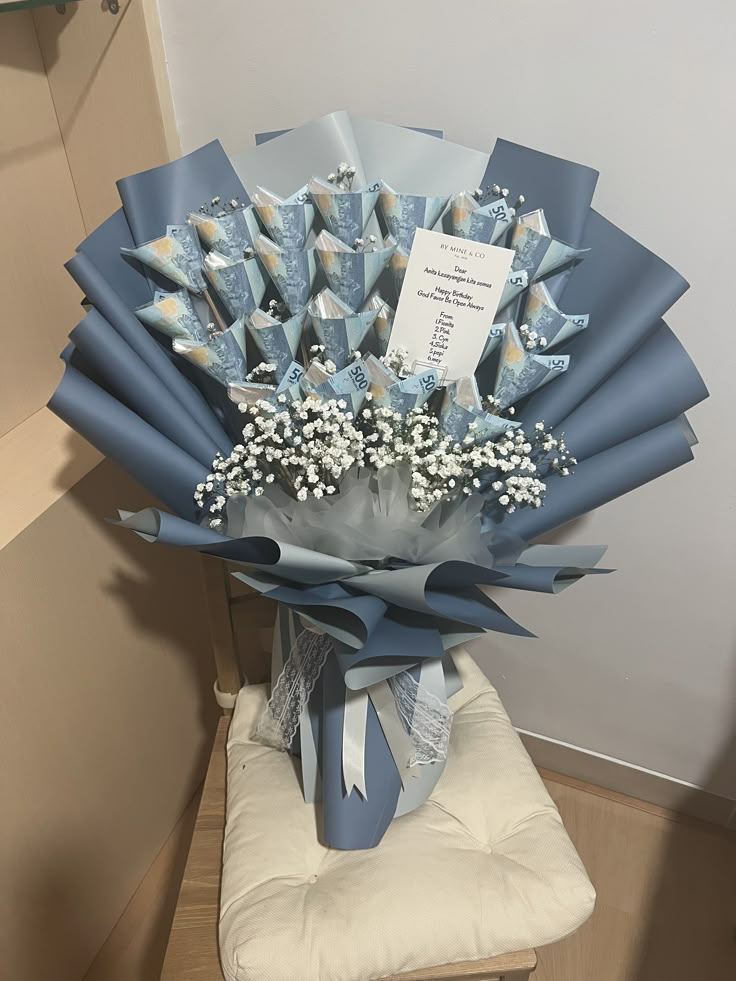 a bouquet of baby's breath in a blue vase on a white chair cushion