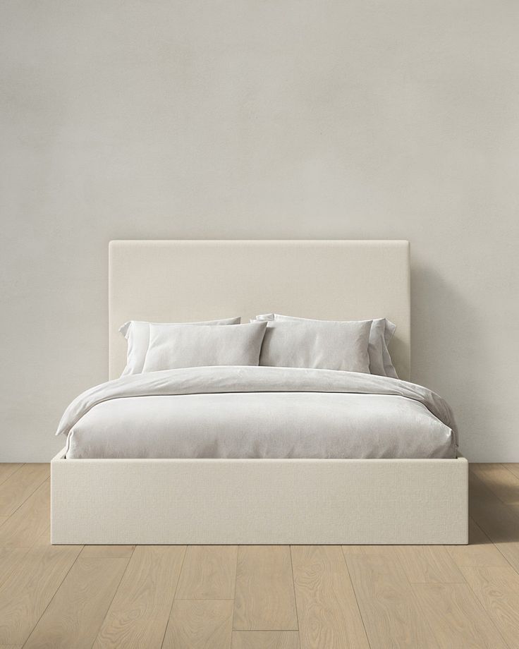 a white bed sitting on top of a wooden floor