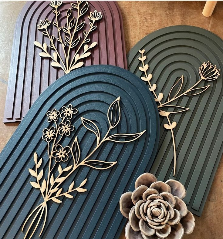 three wooden plaques with flowers and leaves on them