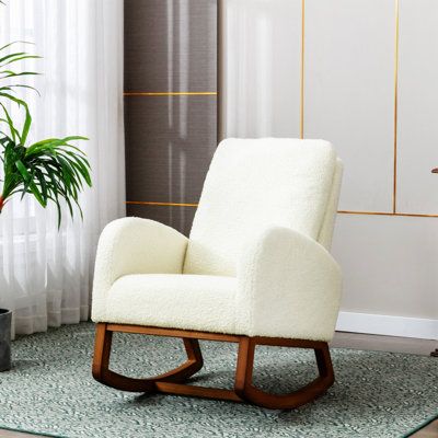 a white chair sitting in front of a window next to a potted green plant