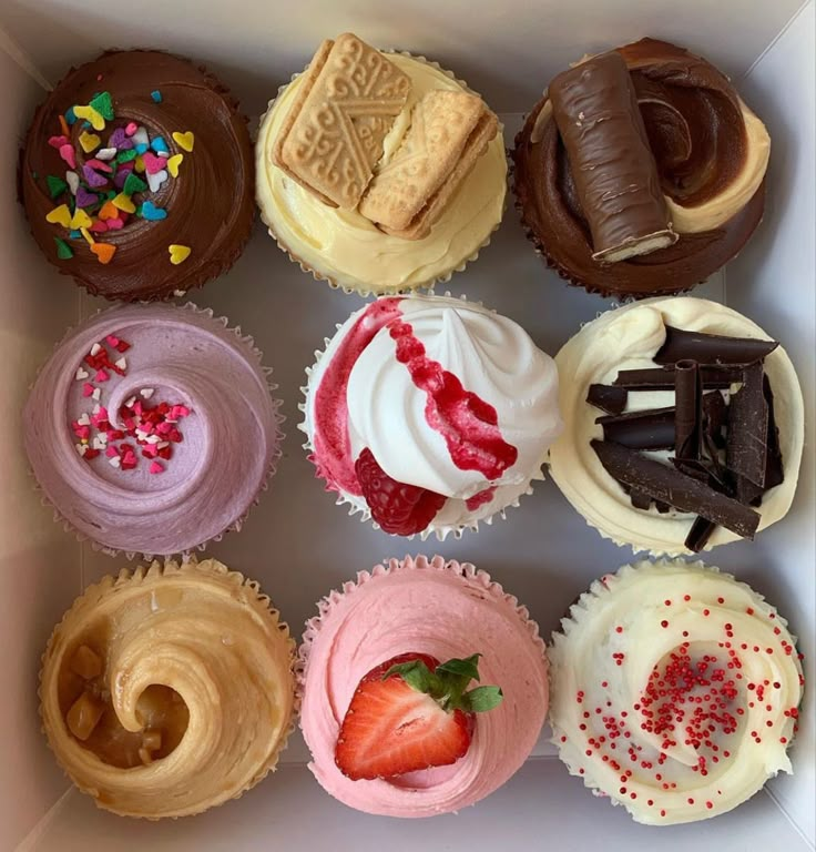 a box filled with lots of different types of cupcakes