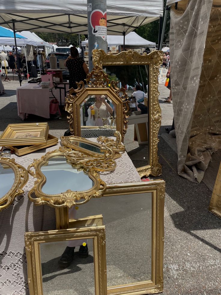 there are many mirrors on display under the tent