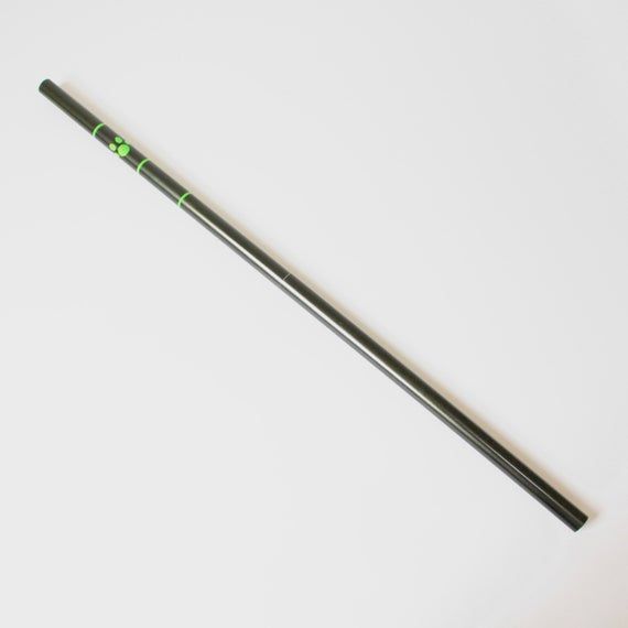 a black and green pencil laying on top of a white surface