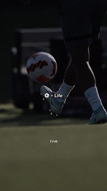 a person kicking a soccer ball on top of a field