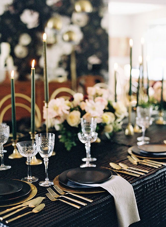 the table is set with black and gold place settings