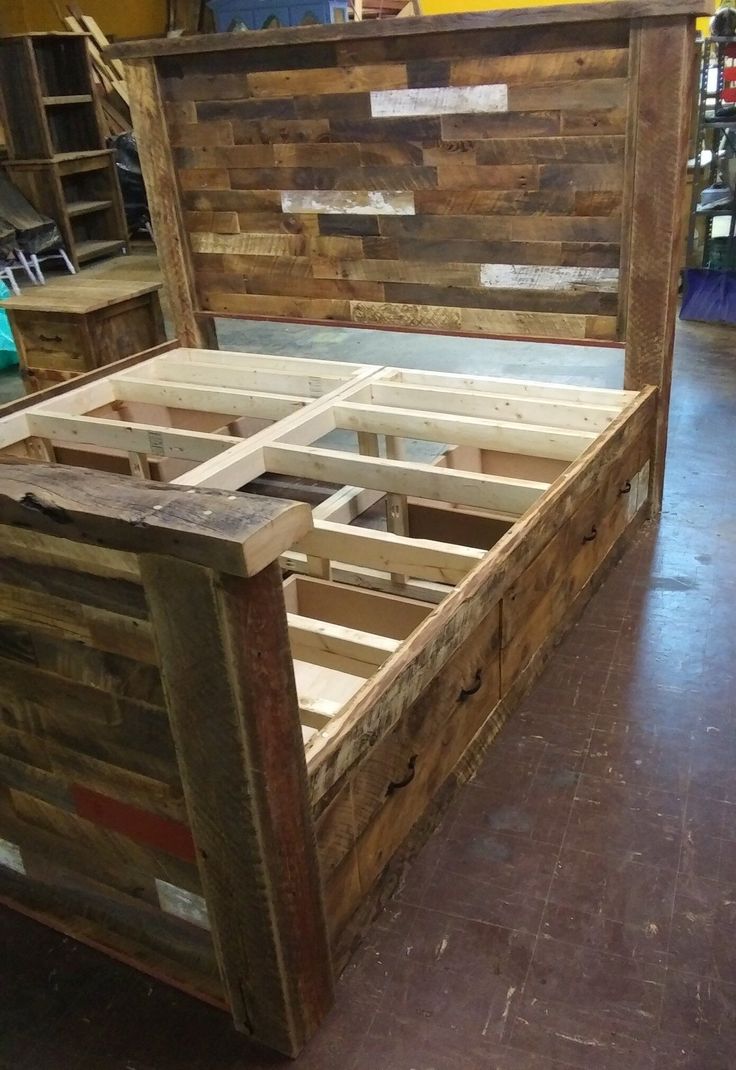 a bed frame made out of wooden pallets in a room filled with other furniture