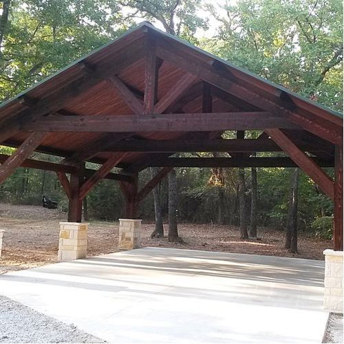 a wooden pavilion in the middle of a park