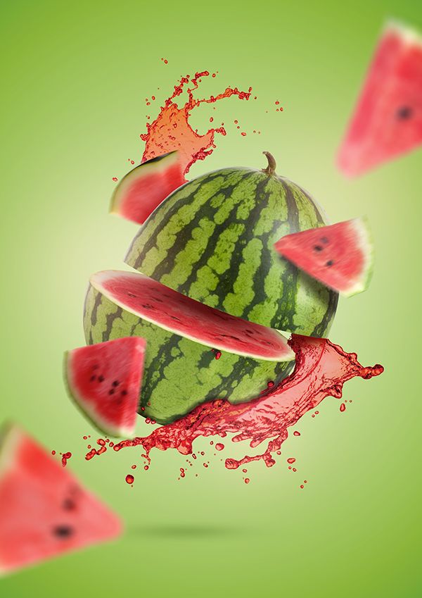 watermelon slices falling into red liquid on green background with splashing around them