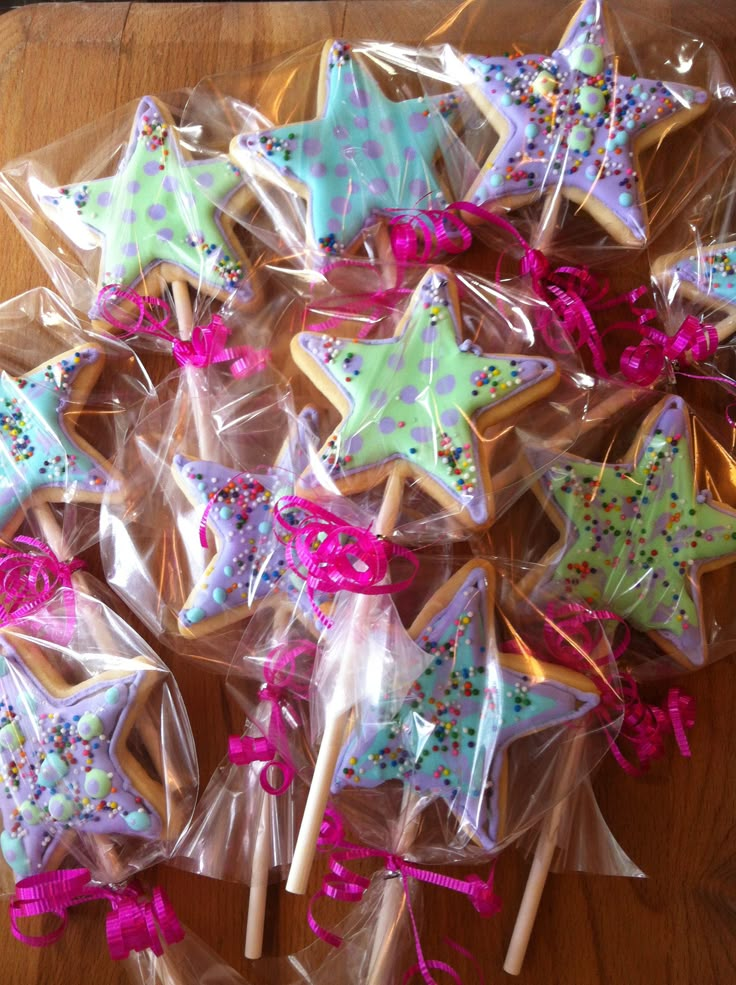 star shaped cookies wrapped in cellophane and tied with pink ribbon on wooden table