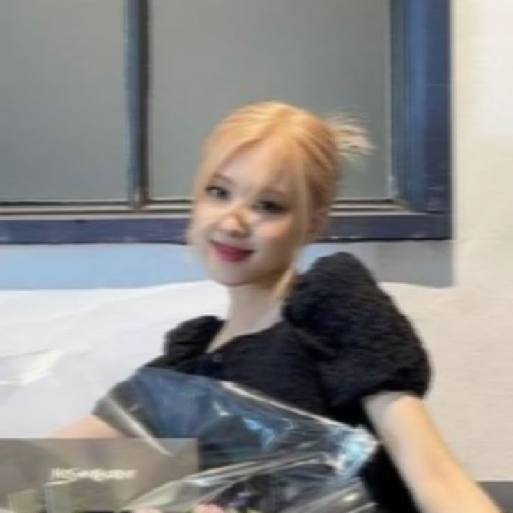 a woman sitting on top of a bed holding a plastic bag