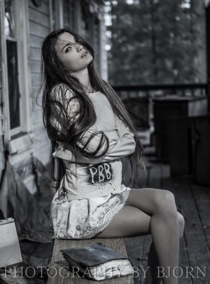 a woman sitting on top of a wooden bench