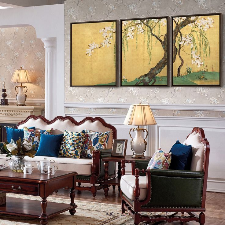 a living room filled with furniture and paintings on the wall