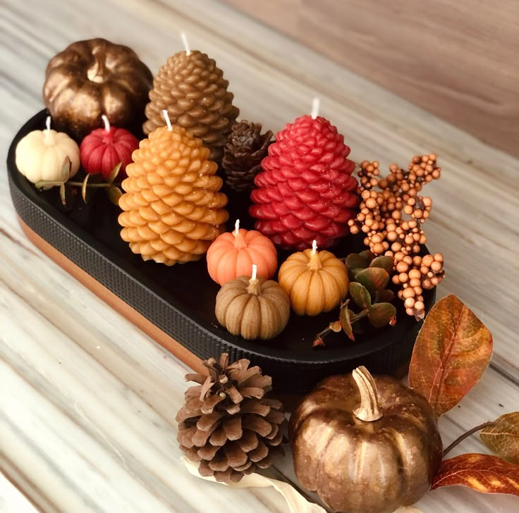 there are many pine cones and small pumpkins on the table