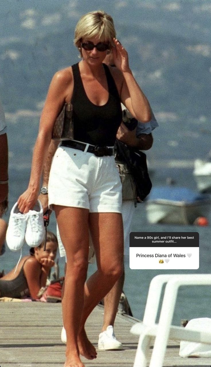 a woman walking down a pier talking on a cell phone