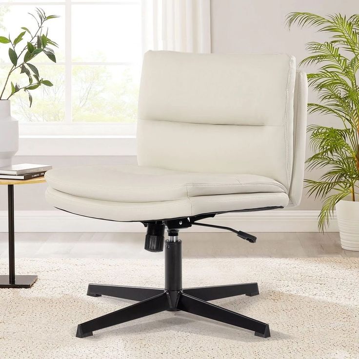 a white office chair sitting on top of a rug in front of a potted plant