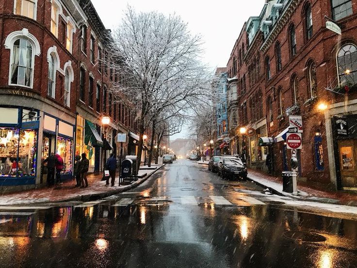 people are walking down the street on a snowy day