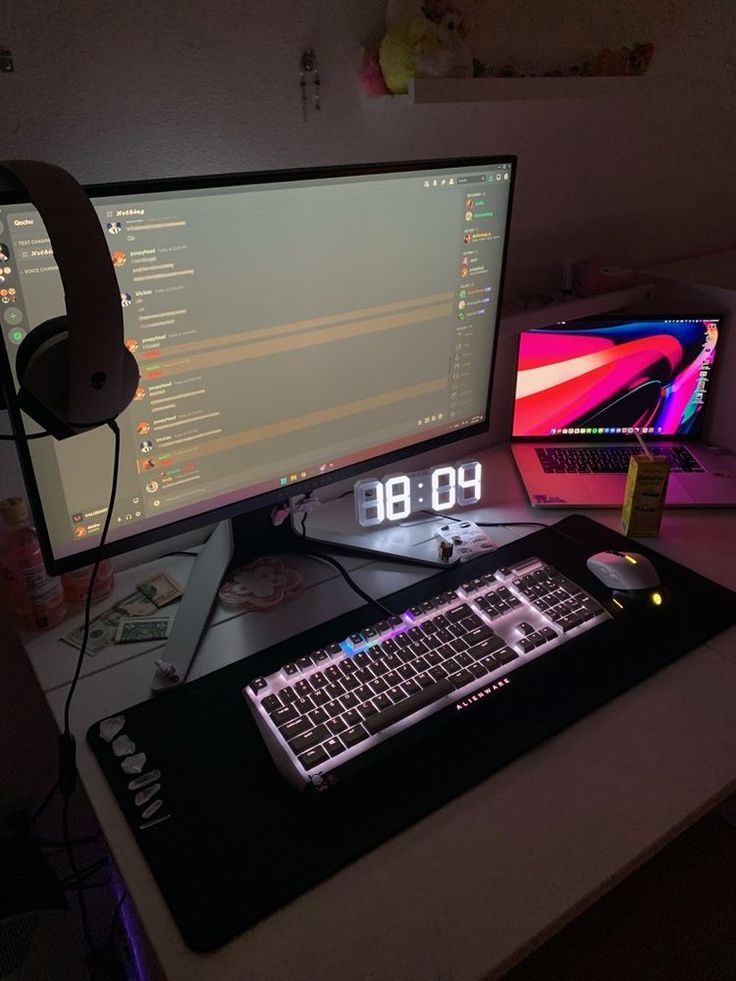 a computer desk with two monitors and headphones