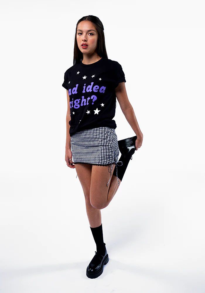 a young woman is posing for the camera wearing a t - shirt with stars on it