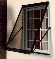 an open window on the side of a brick building with bars hanging from it's sides