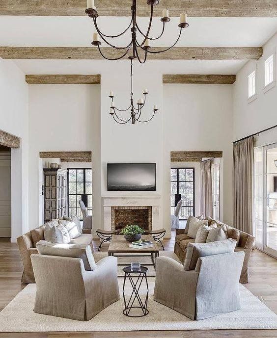 a living room with couches, chairs and a chandelier hanging from the ceiling