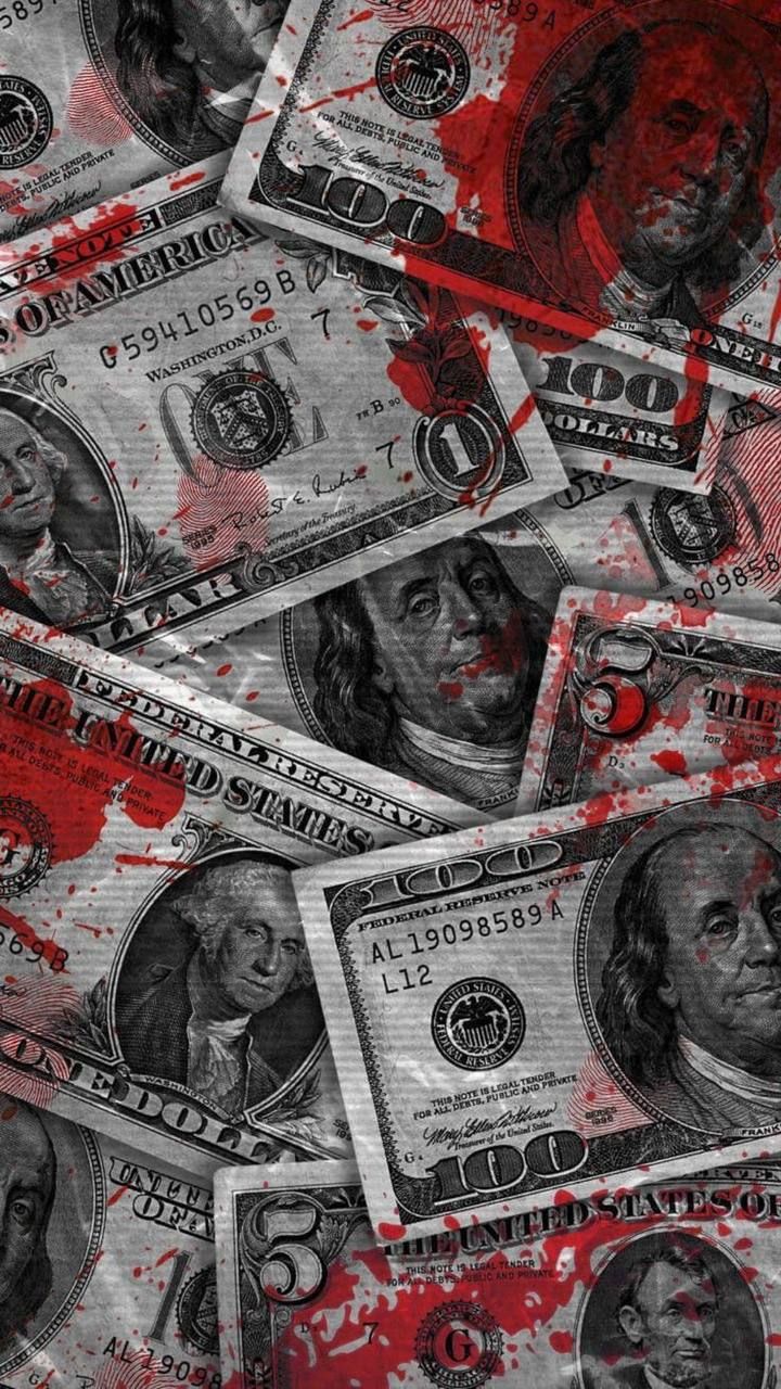 a bunch of money that is on top of some red and black paper with blood all over it