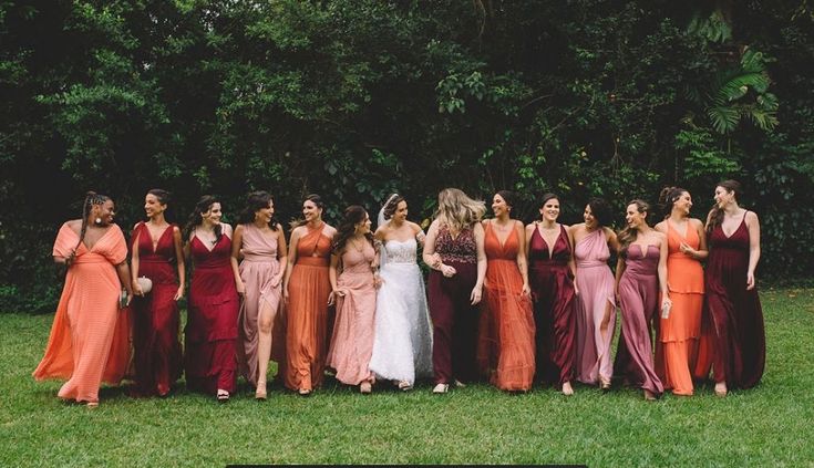 a group of women standing next to each other on top of a lush green field