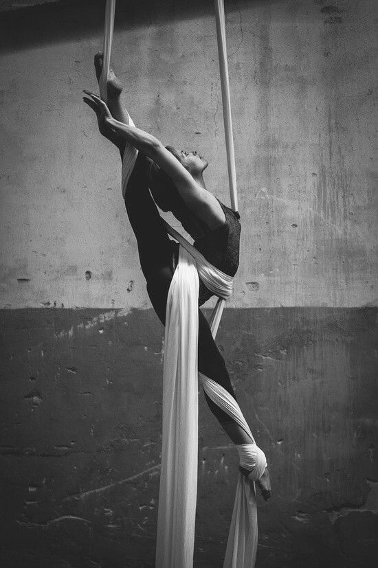 a woman is doing aerial acrobatics on a pole