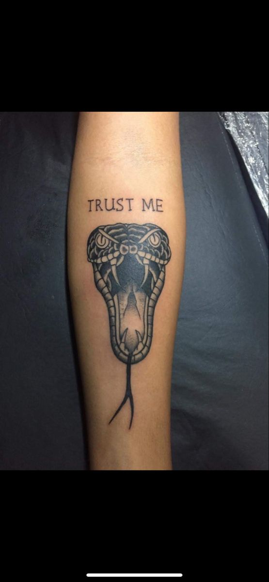 a tattoo on the leg of a person with a snake head and trust me written on it