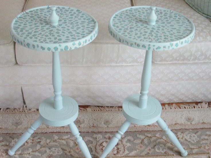 two white tables sitting on top of a carpeted floor