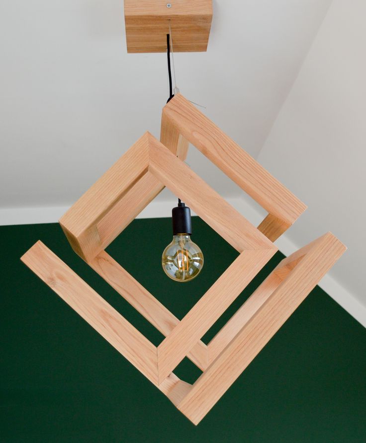 a light fixture hanging from the ceiling in a room with green carpet and white walls