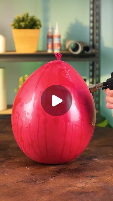 a person is painting a red ball on a table