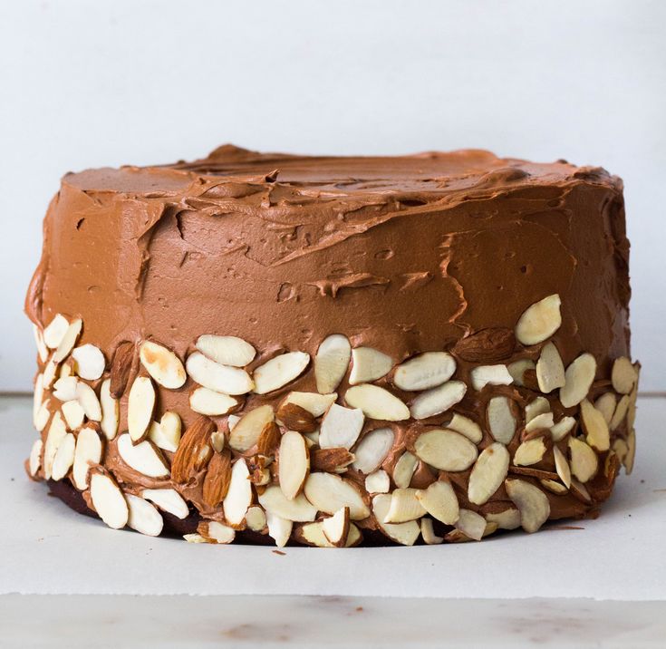 a chocolate cake topped with nuts on top of a table