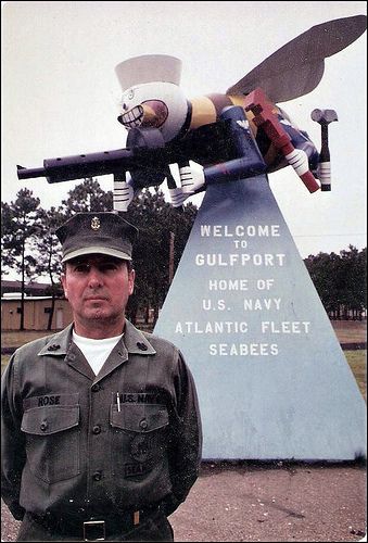 a man in uniform standing next to a statue with an airplane on it's back