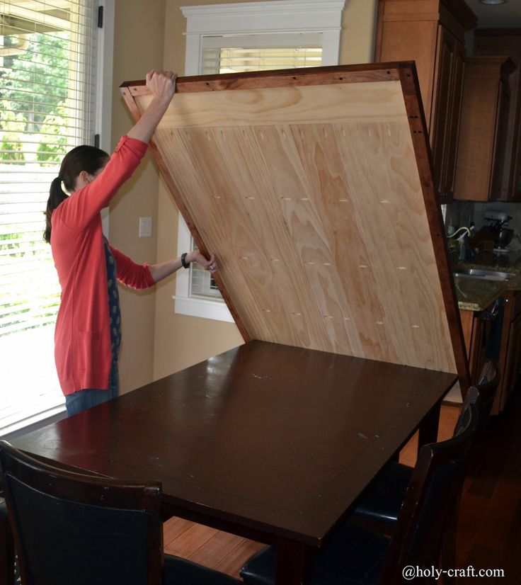 a woman standing next to a table with a large wooden box on top of it